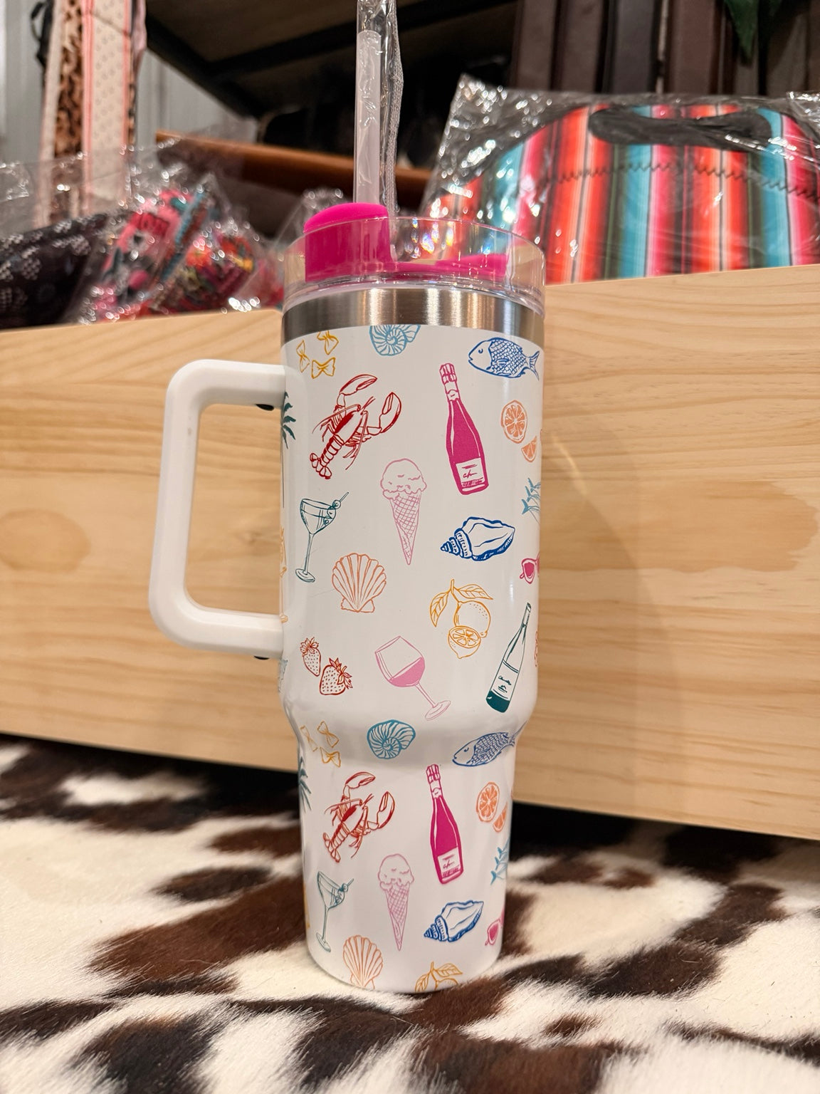 White handled tumbler with colorful coastal icons and pink lid and straw