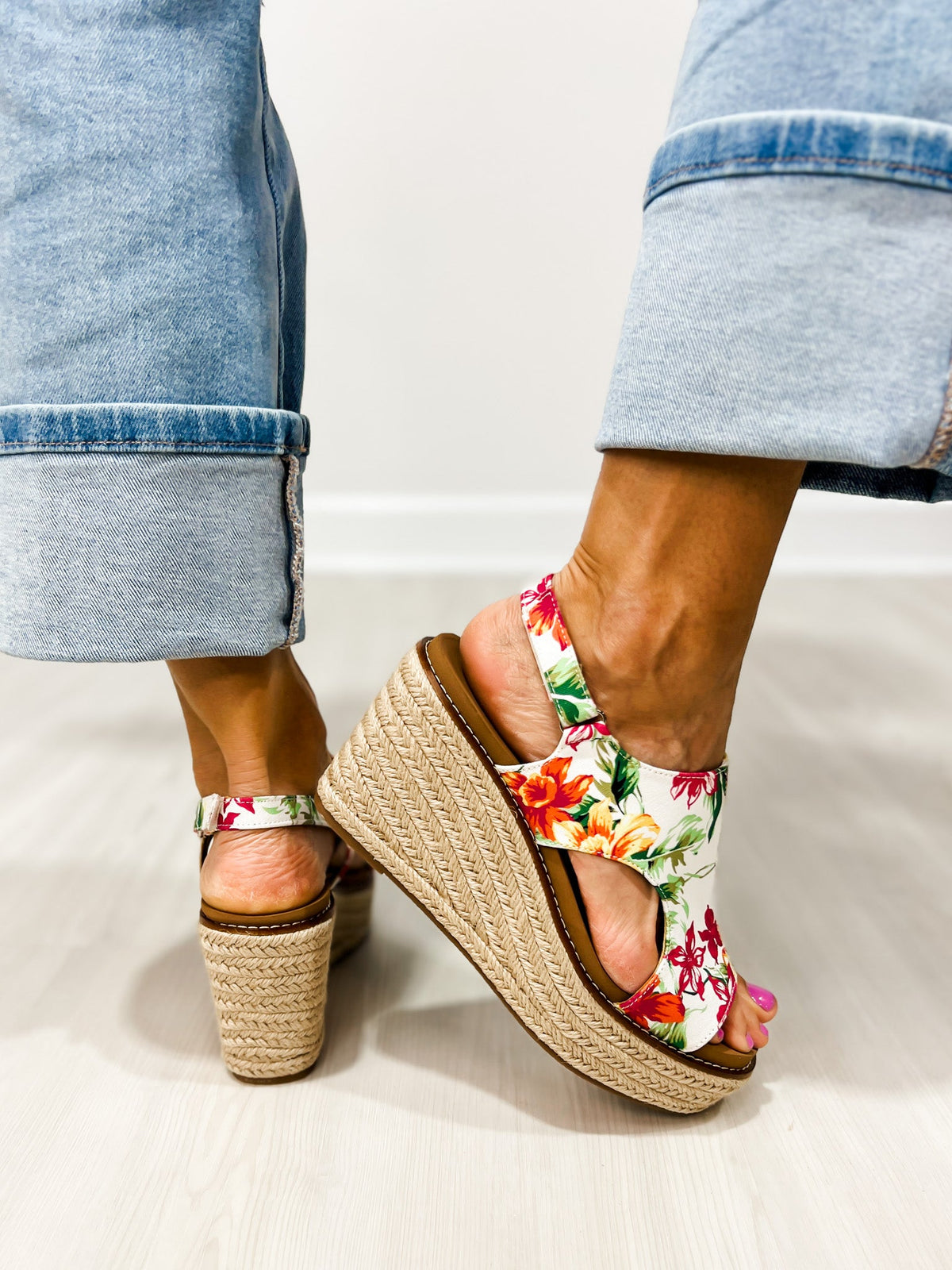 Corkys Freddie white floral wedge sandals on foot